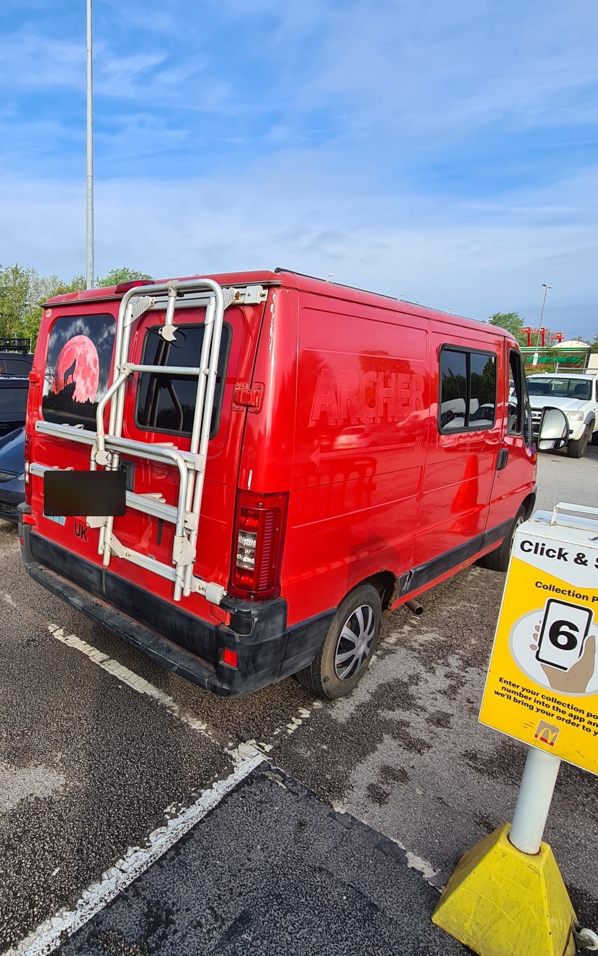 Red Fiat Ducato with custom Archer wolf artwork and rear bike rack